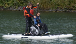 Heinz Ehlers, Referent für Inklusion, mit einer Teilnehmerin auf dem Stand-Up-Paddle-Board am Banter See.