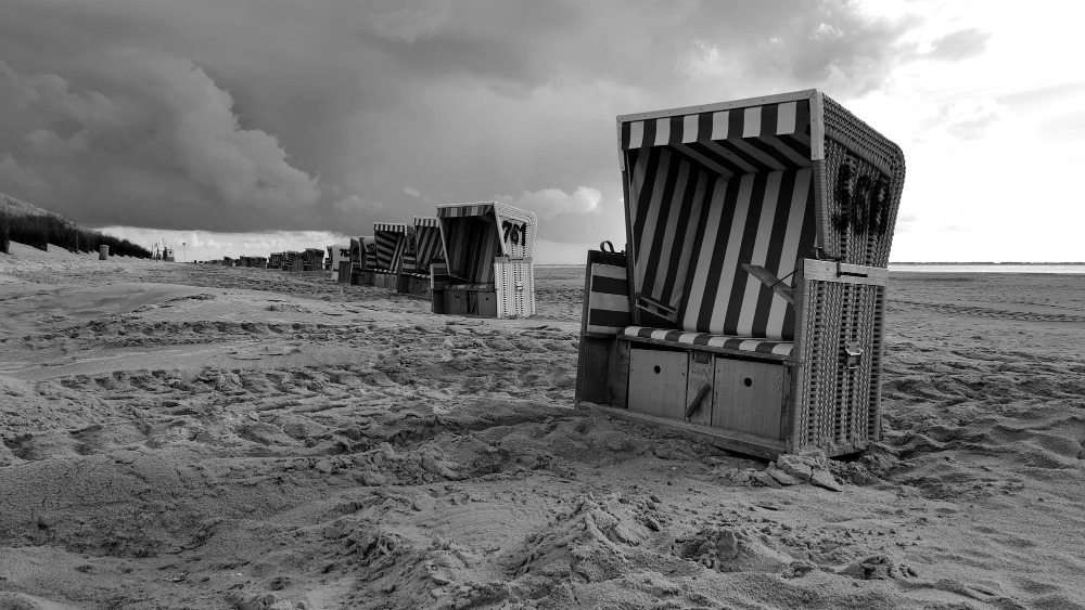 Strandkorb steht am Strand in schwarz-weiß. Umgebung ist sehr Düster. Designed by Freepik.