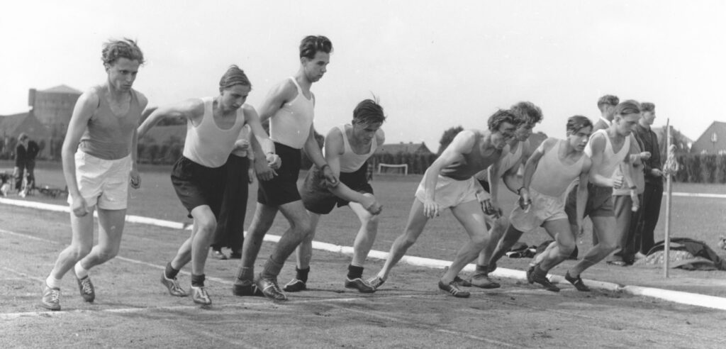 Schüler laufen über eine Ziellinie auf einem Sportplatz