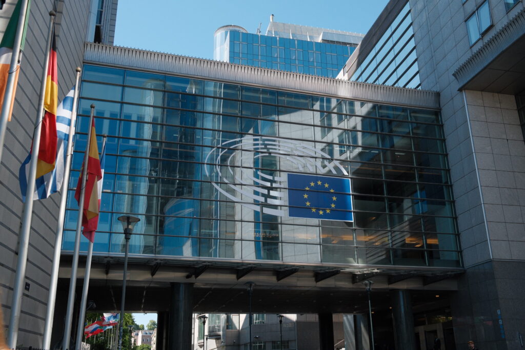 Foto des Europäischen Parlaments in Brüssel. Links vom Bild sind Flaggen zu sehen. FotoI EPRS-Briefing “European Parliament: Facts and figures“, erstellt von Lucille Killmayer, Europäisches Parlament, Brüssel 2024.
