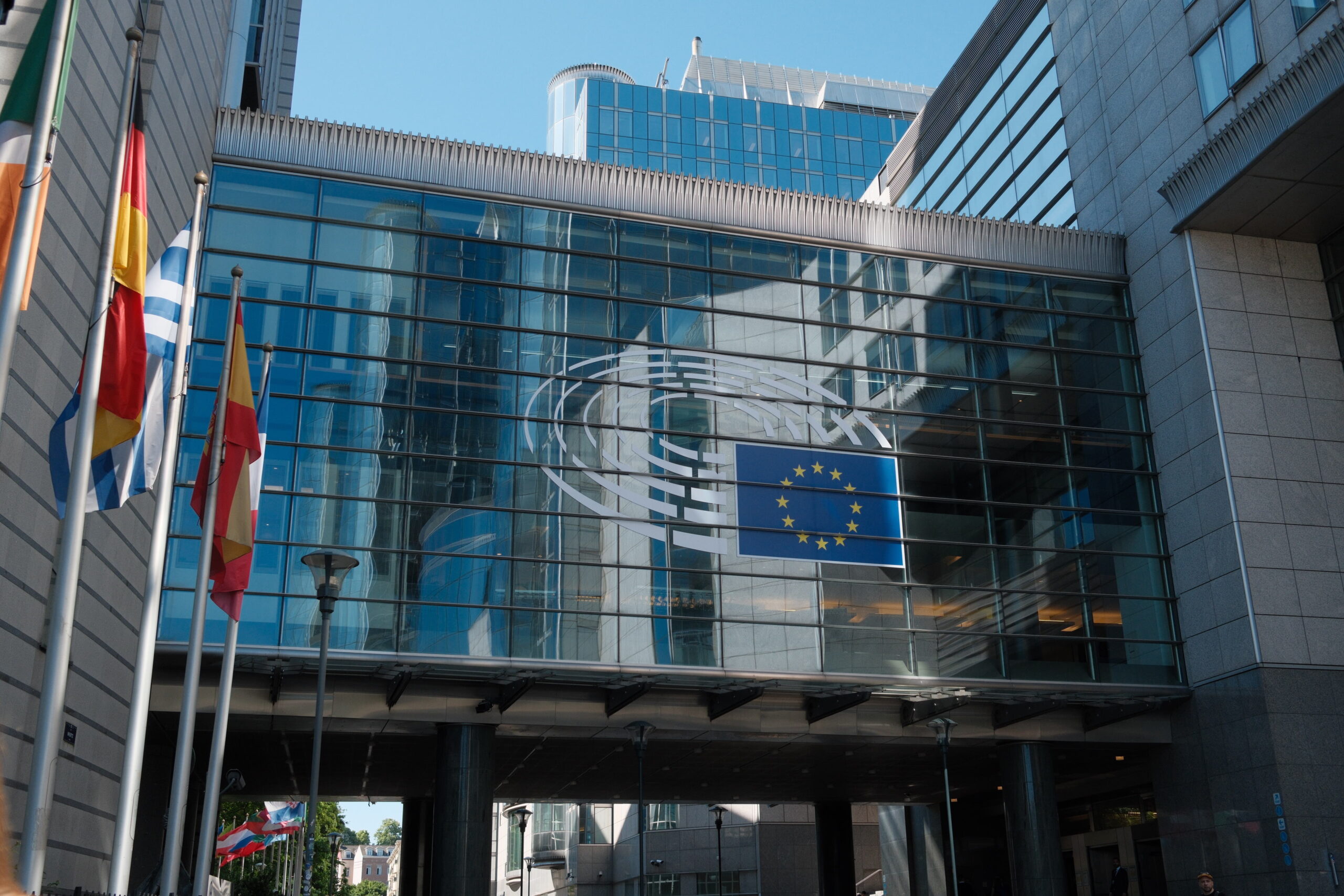 Foto des Europäischen Parlaments in Brüssel. Links vom Bild sind Flaggen zu sehen. FotoI EPRS-Briefing “European Parliament: Facts and figures“, erstellt von Lucille Killmayer, Europäisches Parlament, Brüssel 2024.