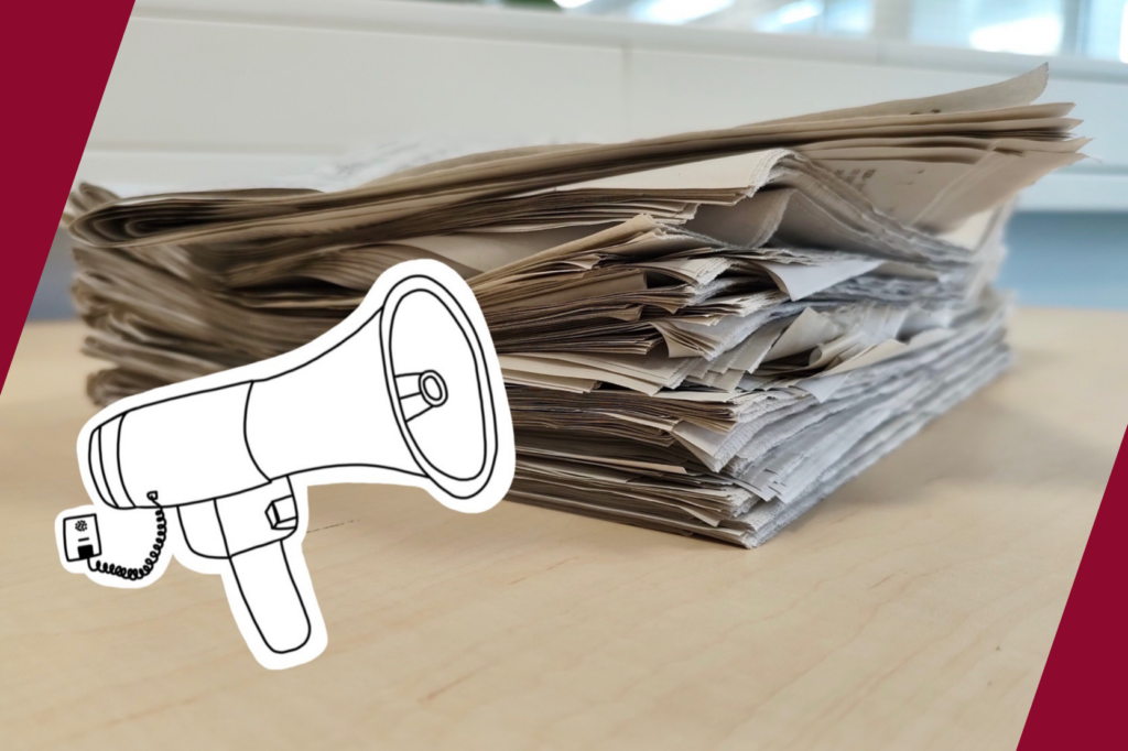 Ein Megafon vor einem Stapel Zeitungen im Hintergrund