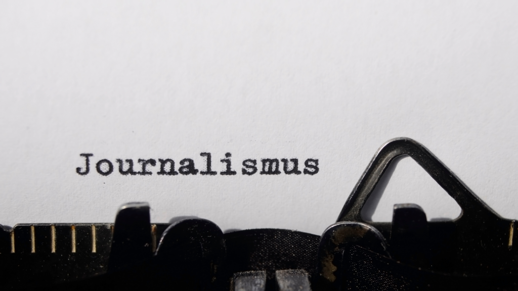 Eine Schreibmaschine mit dem getippten Wort Journalismus
